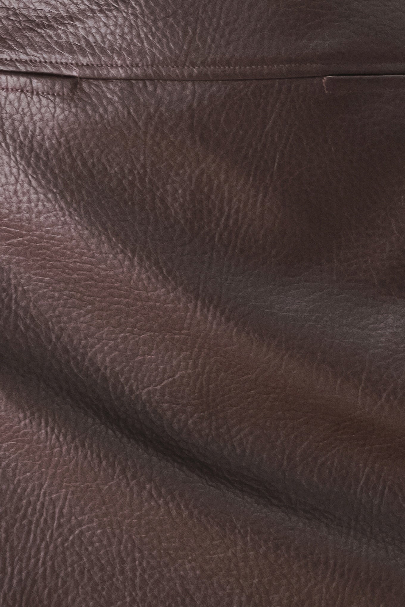 A dark brown faux-leather mini skort with a pebbled texture, worn by a model | FREEMARKET