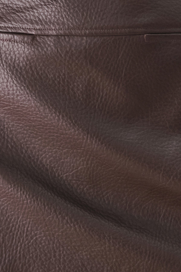 A dark brown faux-leather mini skort with a pebbled texture, worn by a model | FREEMARKET