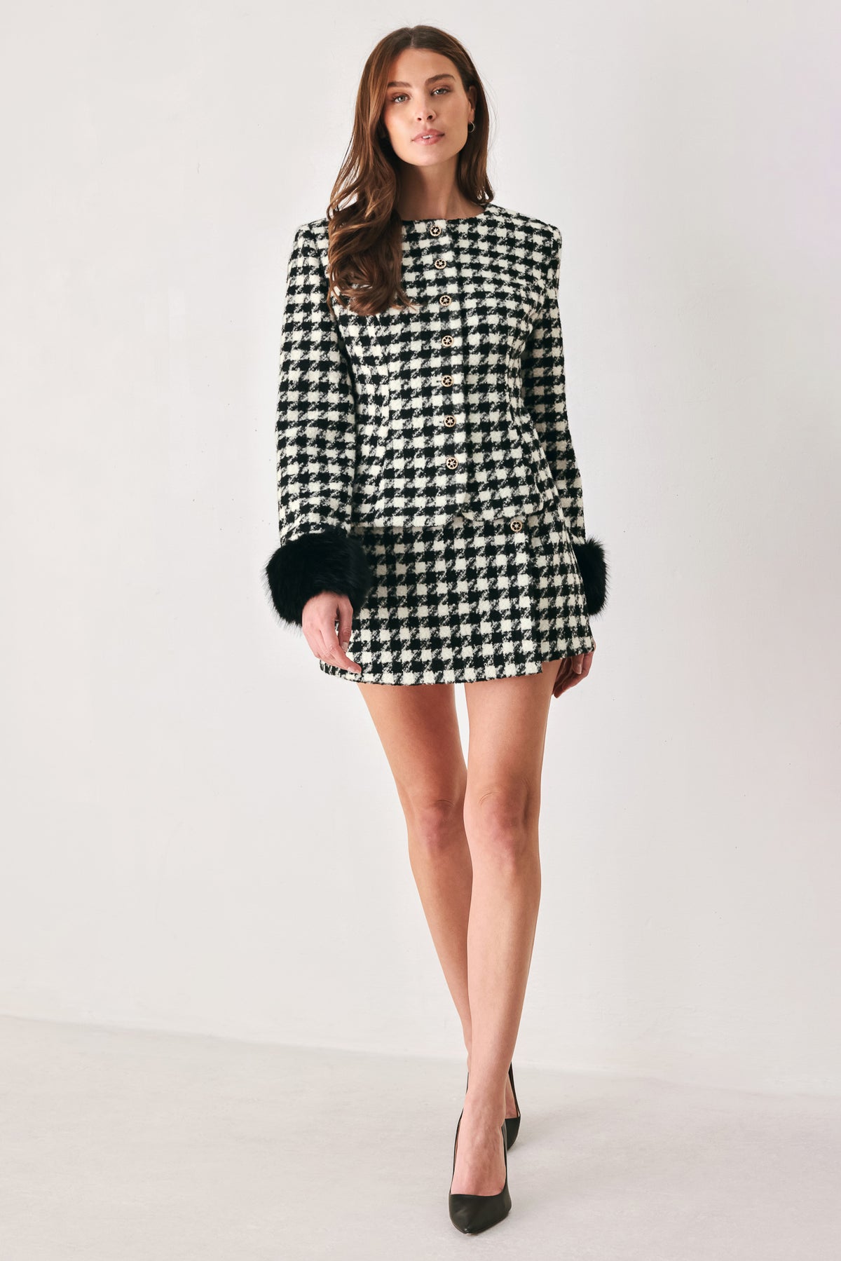 Woman wearing a high waisted black and white houndstooth skort with buttons | FREEMARKET