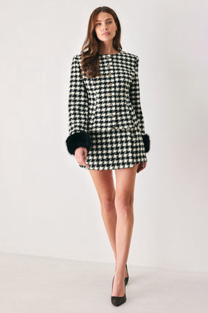 Woman wearing a high waisted black and white houndstooth skort with buttons | FREEMARKET