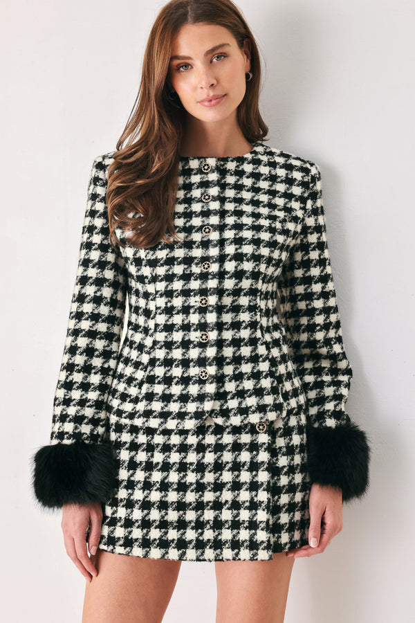 Woman wearing a high waisted black and white houndstooth skort with buttons | FREEMARKET