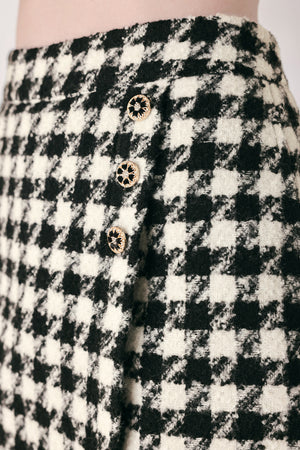 Woman wearing a high waisted black and white houndstooth skort with buttons | FREEMARKET