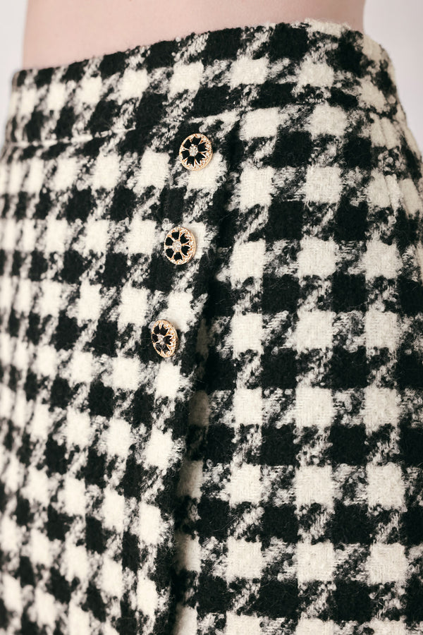 Woman wearing a high waisted black and white houndstooth skort with buttons | FREEMARKET