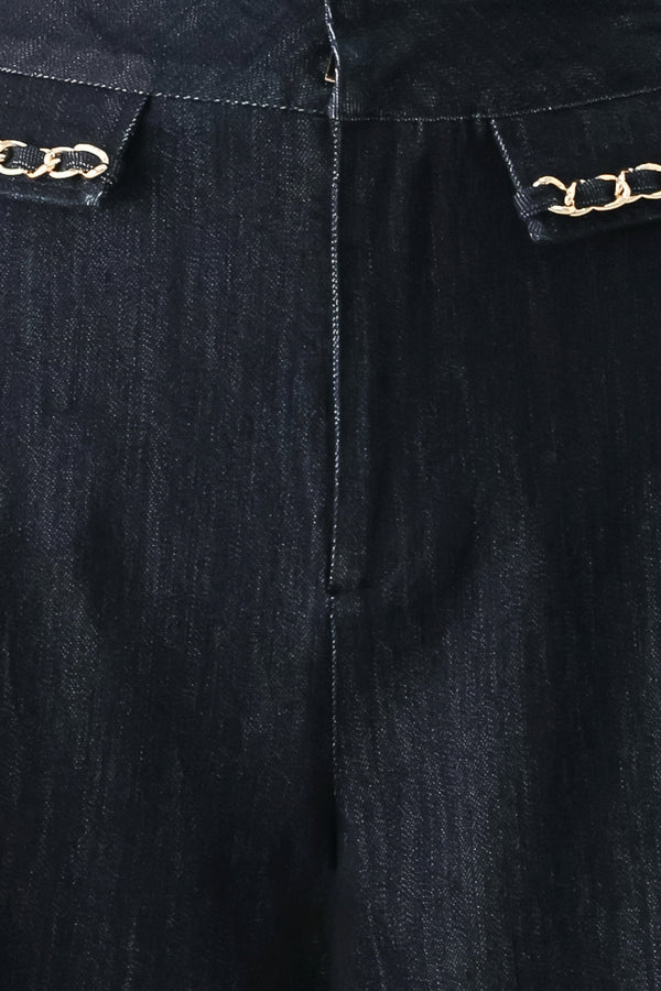 A model wearing dark indigo wide-leg denim jeans with gold chain embellishments on the front pockets | FREEMARKET