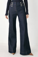 A model wearing dark blue wide-leg denim jeans with decorative silver buttons on the front | FREEMARKET