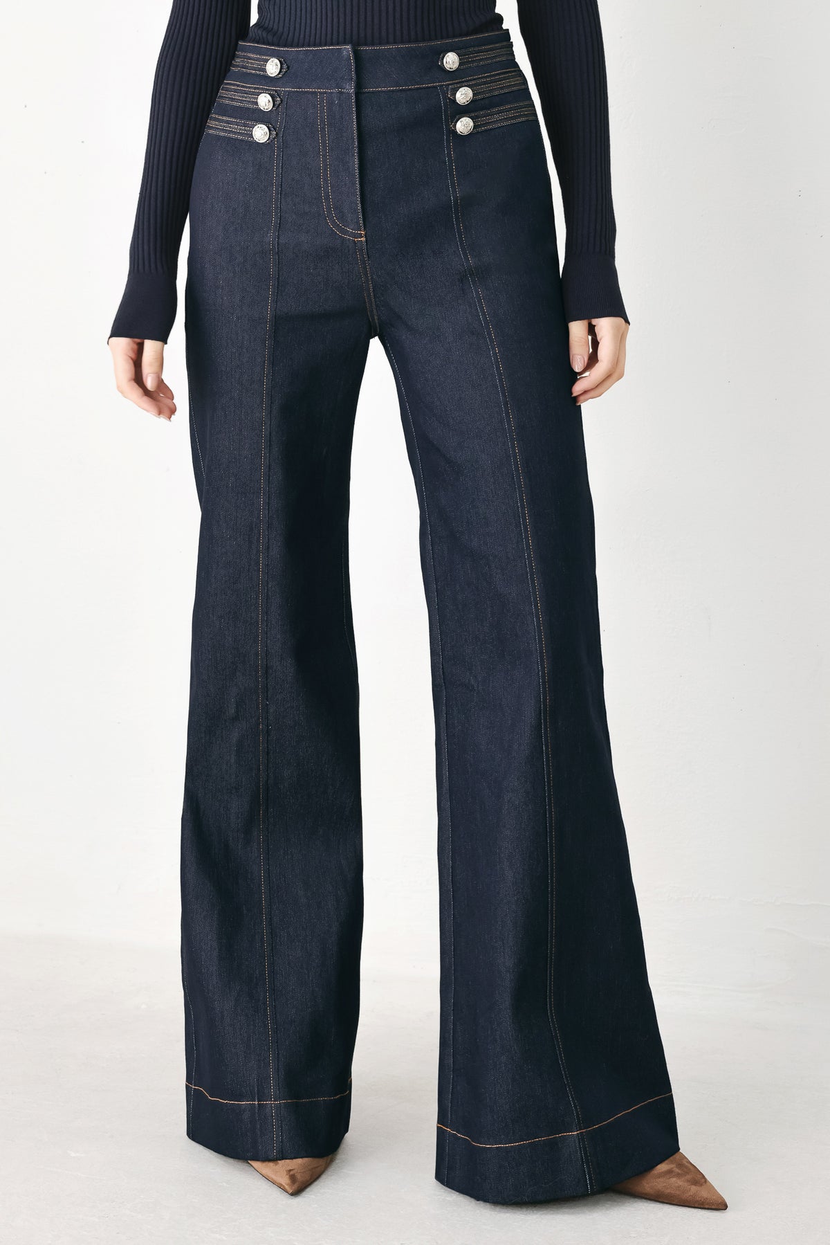 A model wearing dark blue wide-leg denim jeans with decorative silver buttons on the front | FREEMARKET
