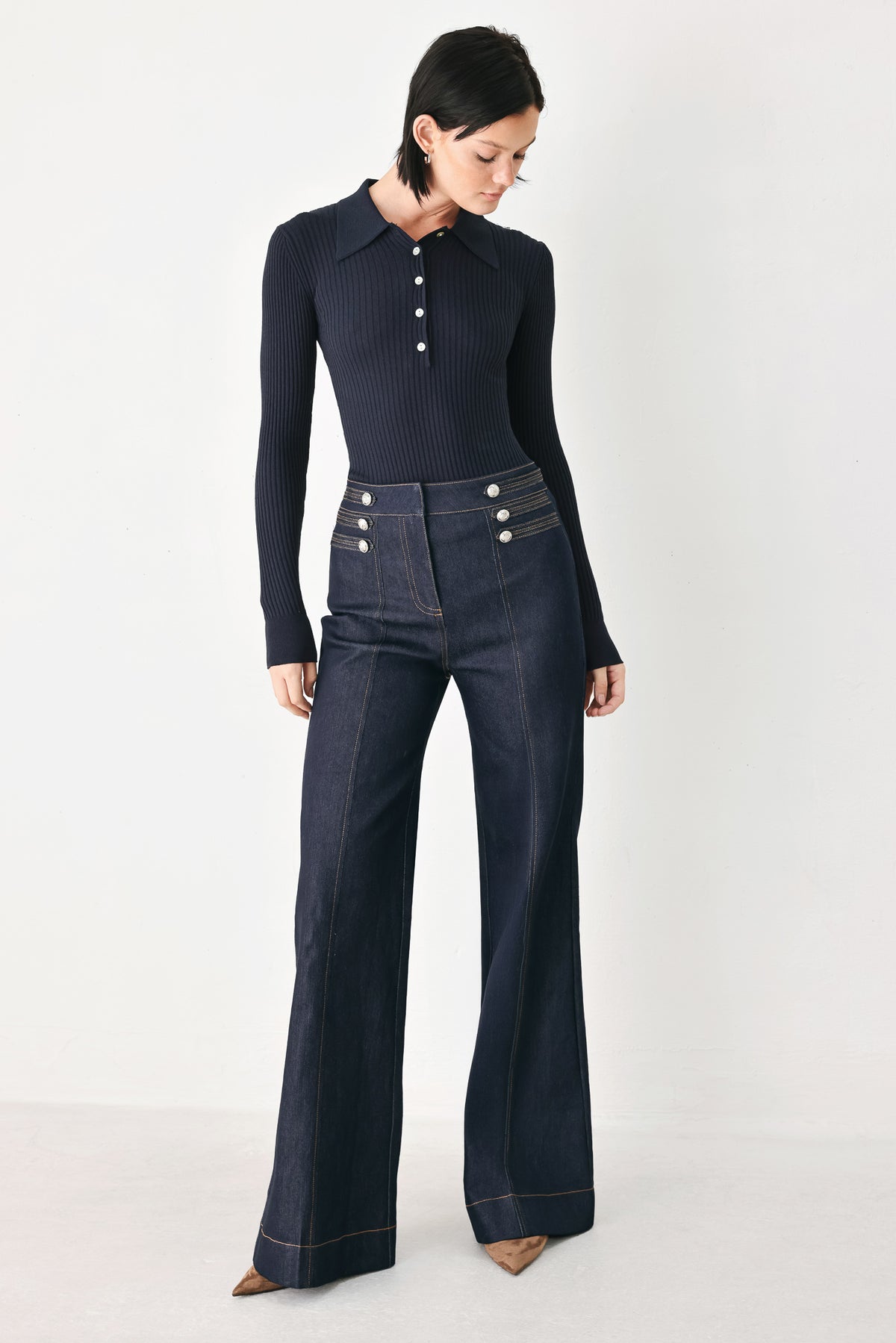 A model wearing dark blue wide-leg denim jeans with decorative silver buttons on the front | FREEMARKET
