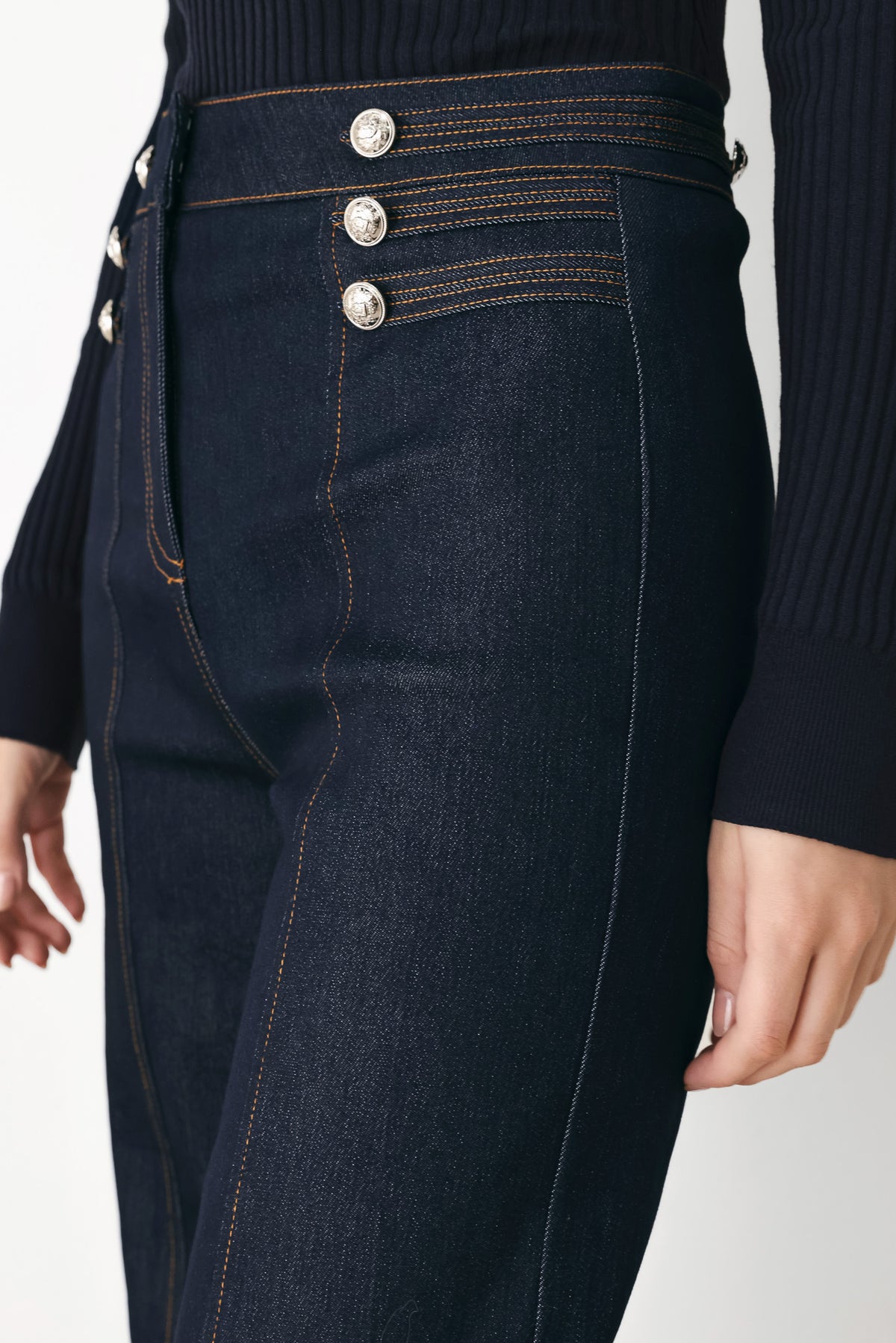 A model wearing dark blue wide-leg denim jeans with decorative silver buttons on the front | FREEMARKET