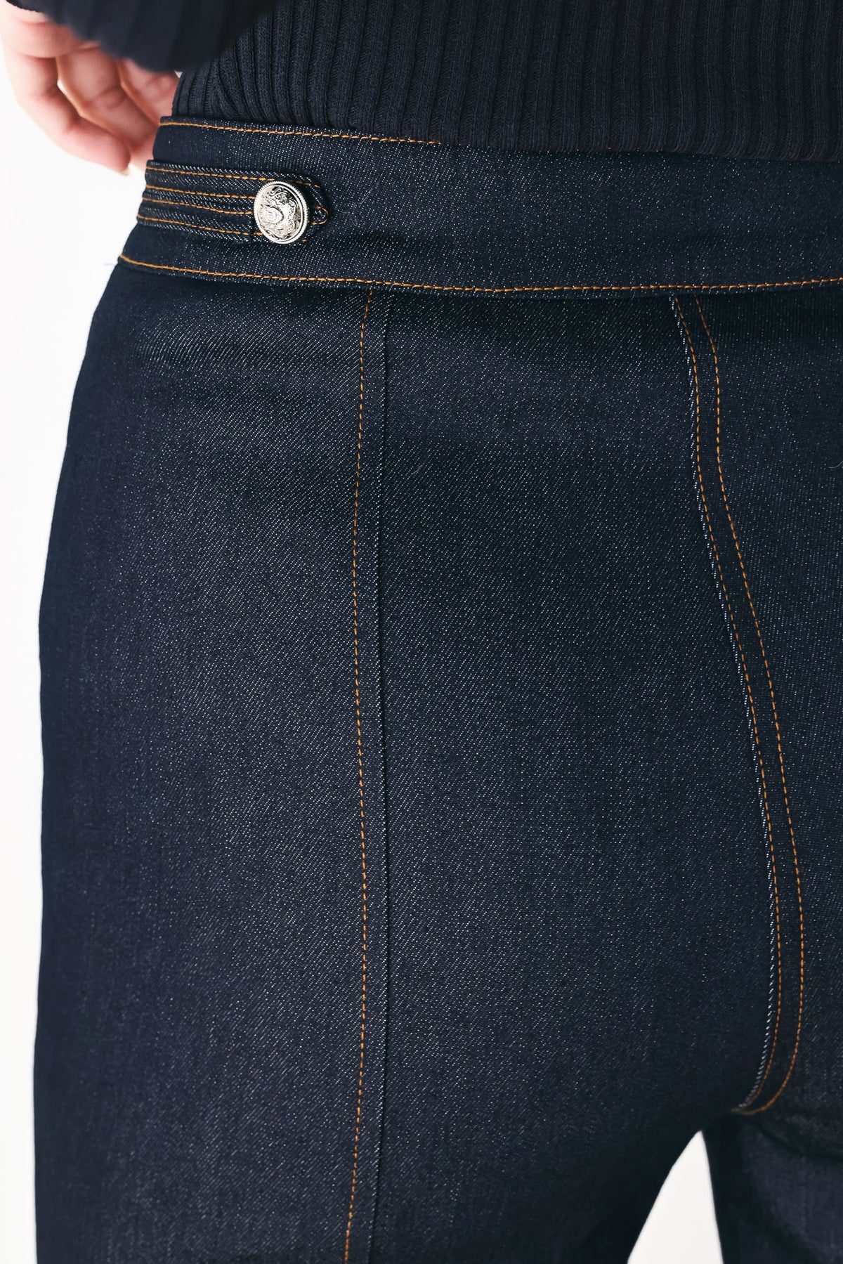 A model wearing dark blue wide-leg denim jeans with decorative silver buttons on the front | FREEMARKET