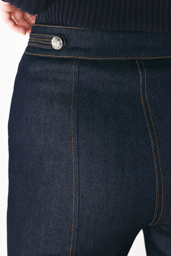 A model wearing dark blue wide-leg denim jeans with decorative silver buttons on the front | FREEMARKET