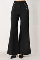 Woman wearing a pair of black high waisted pants with buttons going from the waist to the hips and braiding | FREEMARKET