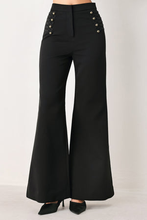 Woman wearing a pair of black high waisted pants with buttons going from the waist to the hips and braiding | FREEMARKET