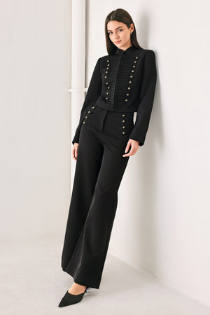 Woman wearing a pair of black high waisted pants with buttons going from the waist to the hips and braiding | FREEMARKET