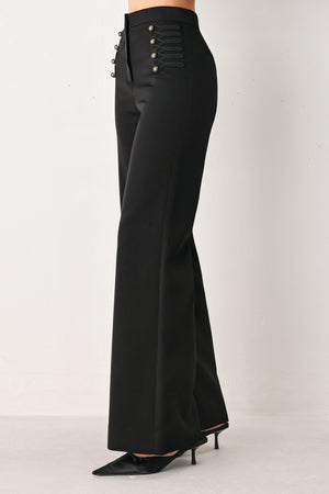 Woman wearing a pair of black high waisted pants with buttons going from the waist to the hips and braiding | FREEMARKET