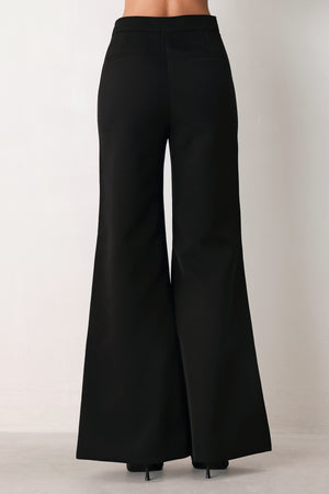 Woman wearing a pair of black high waisted pants with buttons going from the waist to the hips and braiding | FREEMARKET