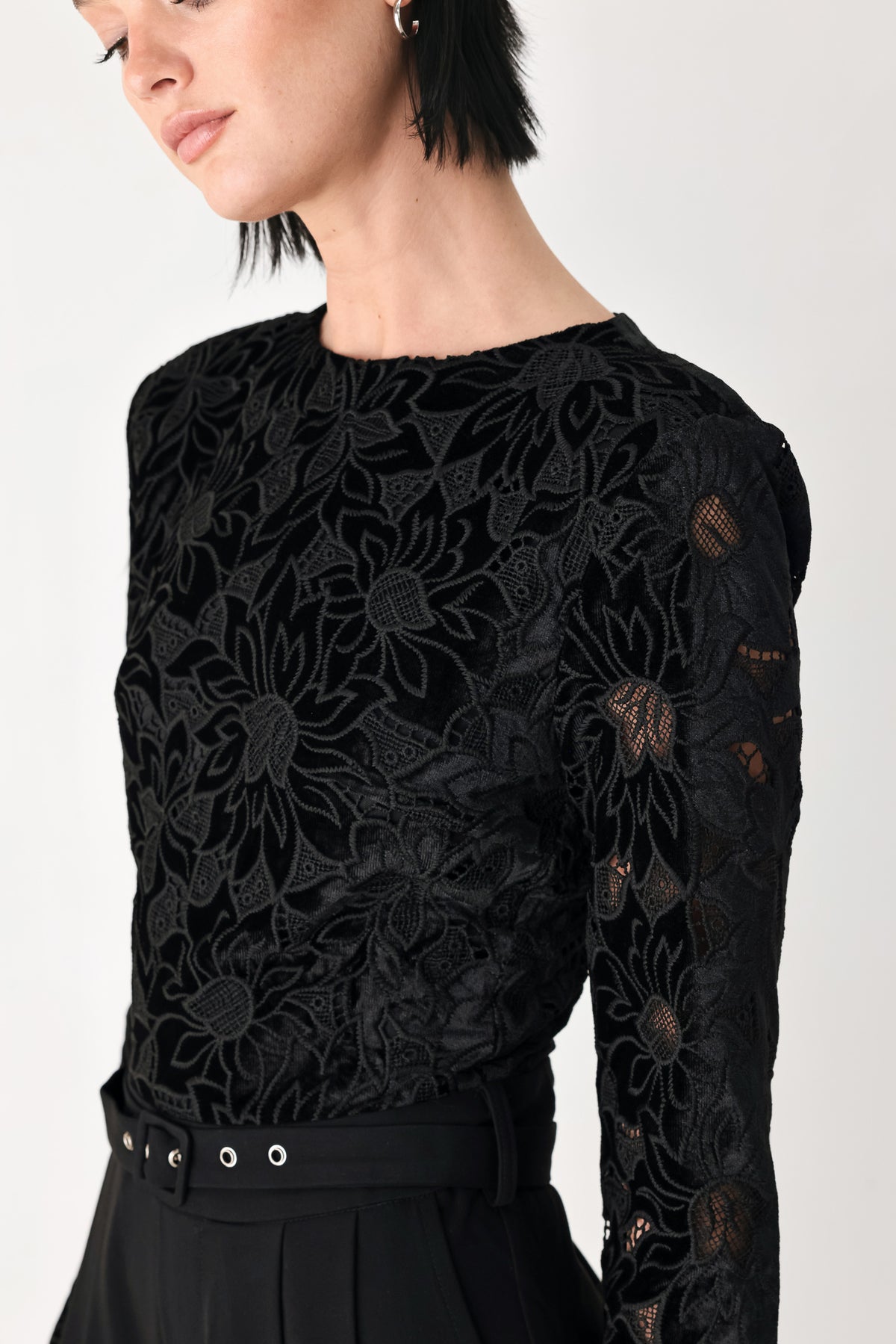 A woman modeling a black long-sleeve jumpsuit with a lace bodice and wide-leg trousers | FREEMARKET