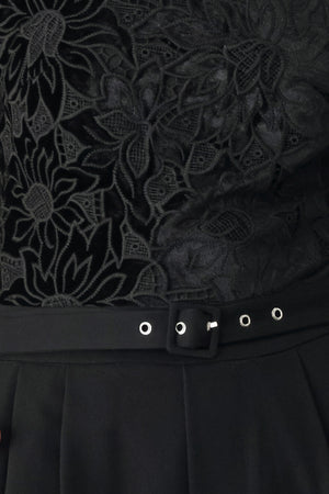 A woman modeling a black long-sleeve jumpsuit with a lace bodice and wide-leg trousers | FREEMARKET