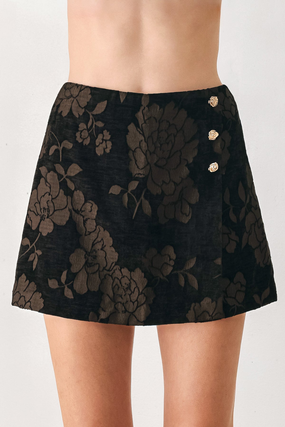 Woman wearing a dark brown mini skort with a brown floral jacquard pattern | FREEMARKET