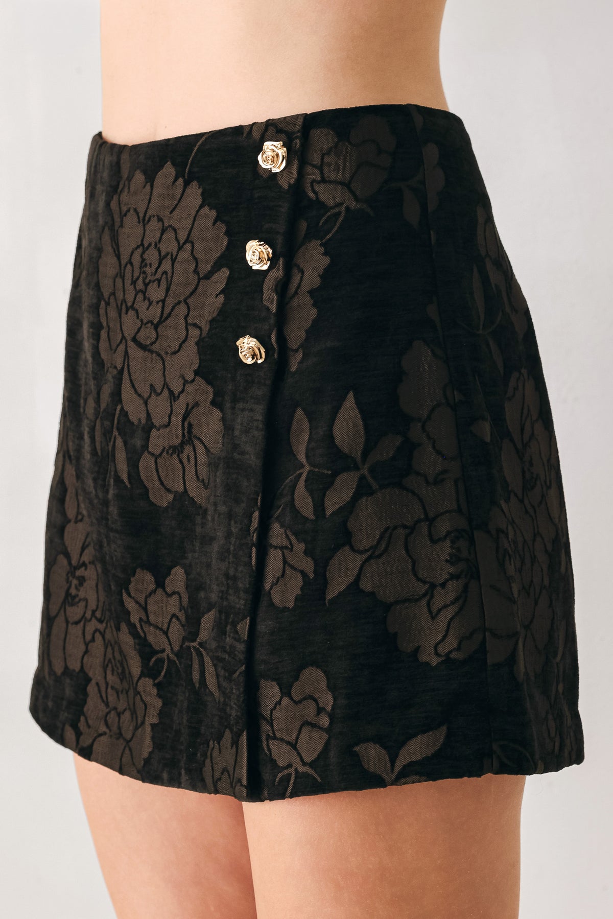 Woman wearing a dark brown mini skort with a brown floral jacquard pattern | FREEMARKET