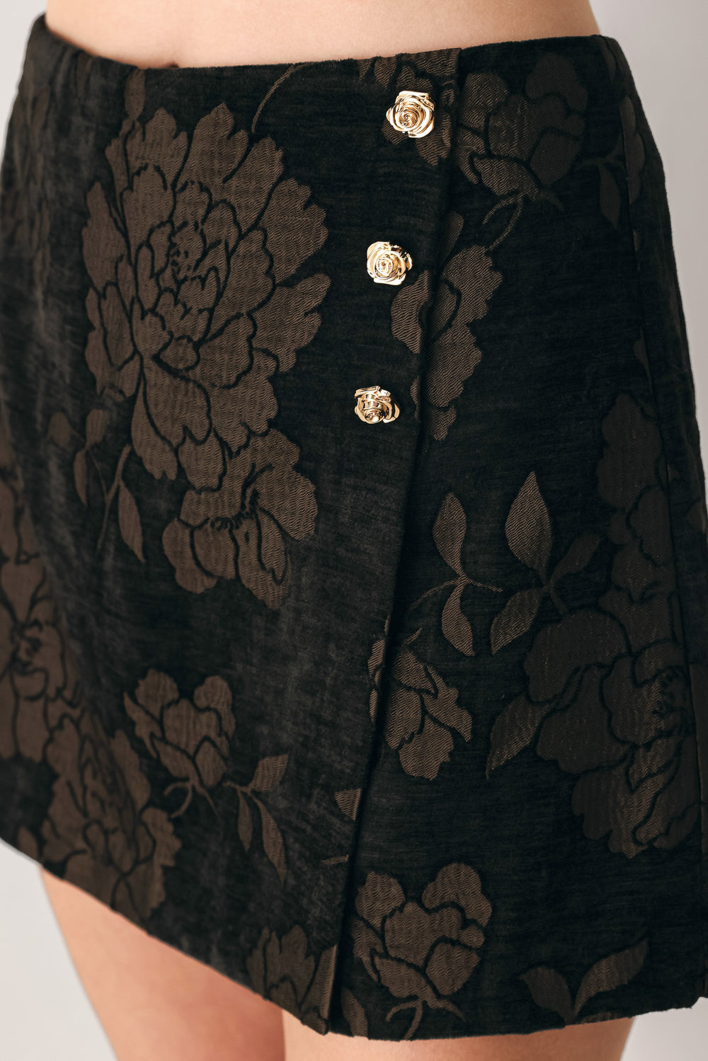 Woman wearing a dark brown mini skort with a brown floral jacquard pattern | FREEMARKET
