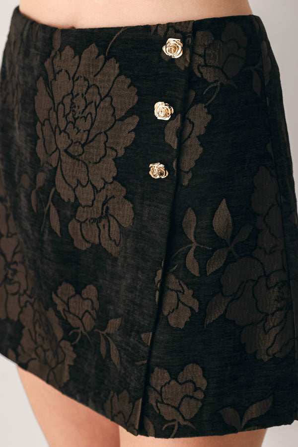Woman wearing a dark brown mini skort with a brown floral jacquard pattern | FREEMARKET