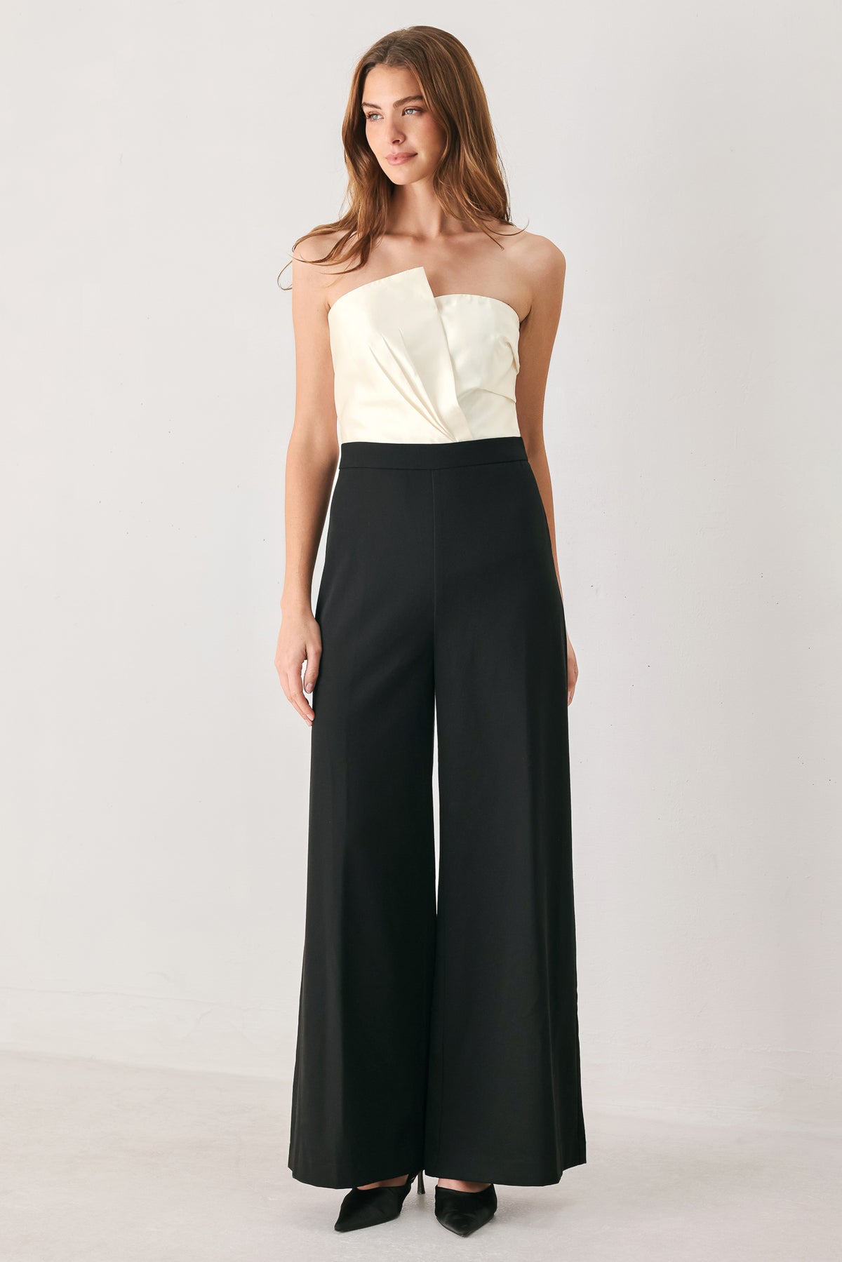 Woman wearing a strapless jumpsuit with white top and black bottom | FREEMARKET