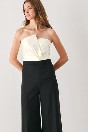 Woman wearing a strapless jumpsuit with white top and black bottom | FREEMARKET