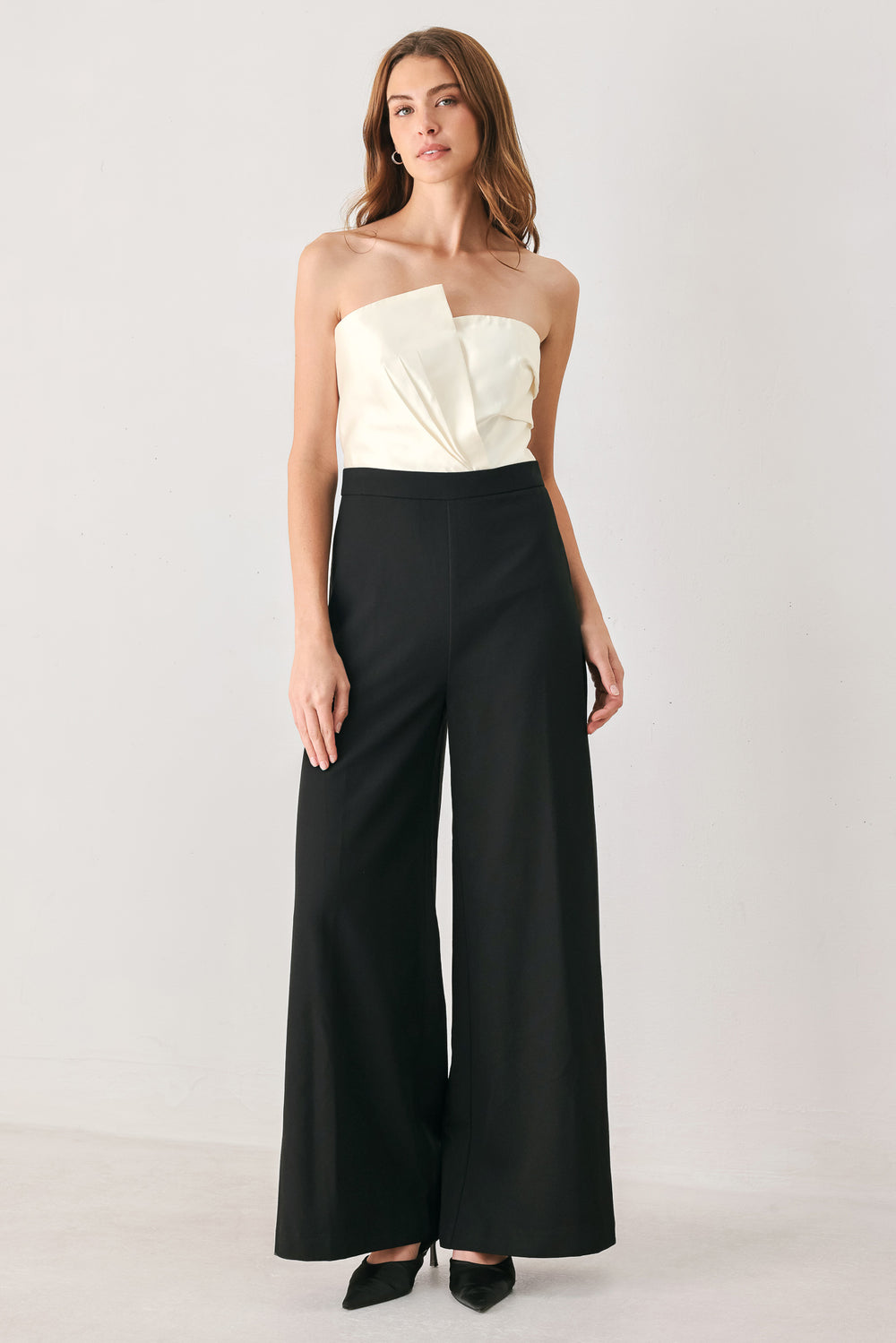 Woman wearing a strapless jumpsuit with white top and black bottom | FREEMARKET