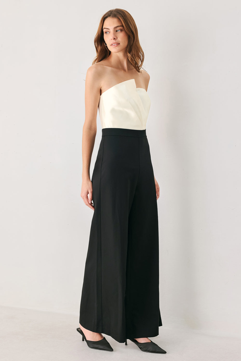 Woman wearing a strapless jumpsuit with white top and black bottom | FREEMARKET