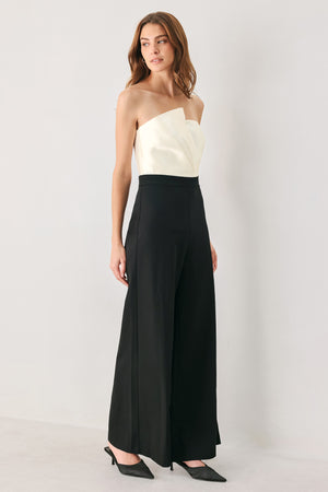 Woman wearing a strapless jumpsuit with white top and black bottom | FREEMARKET