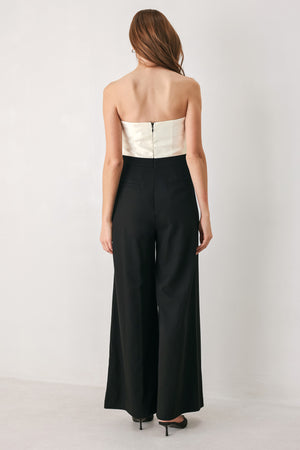 Woman wearing a strapless jumpsuit with white top and black bottom | FREEMARKET