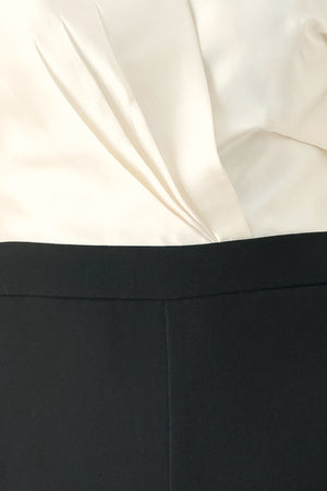 Woman wearing a strapless jumpsuit with white top and black bottom | FREEMARKET