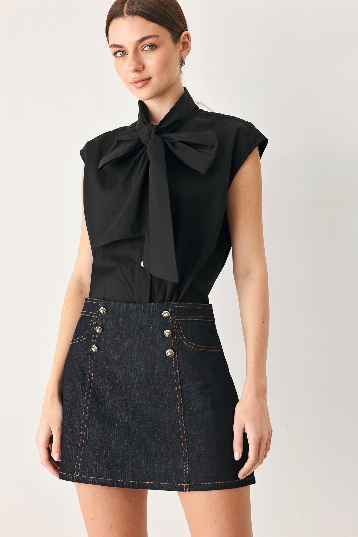Woman wearing a dark lightweight denim skort with front button detail, pockets and back zipper closure | FREEMARKET