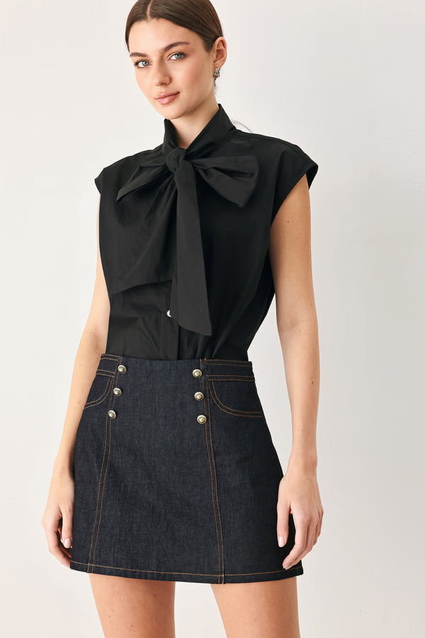 Woman wearing a dark lightweight denim skort with front button detail, pockets and back zipper closure | FREEMARKET