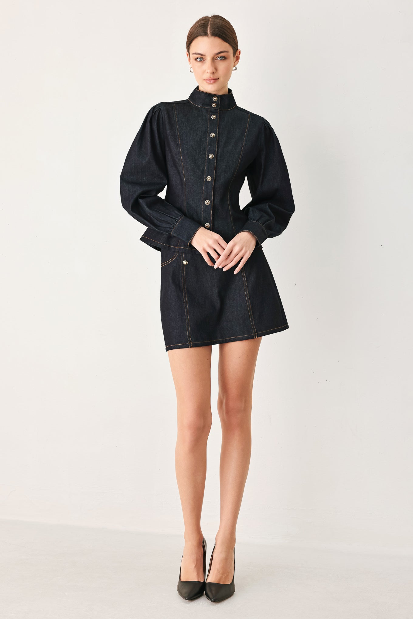Woman wearing a dark lightweight denim skort with front button detail, pockets and back zipper closure | FREEMARKET