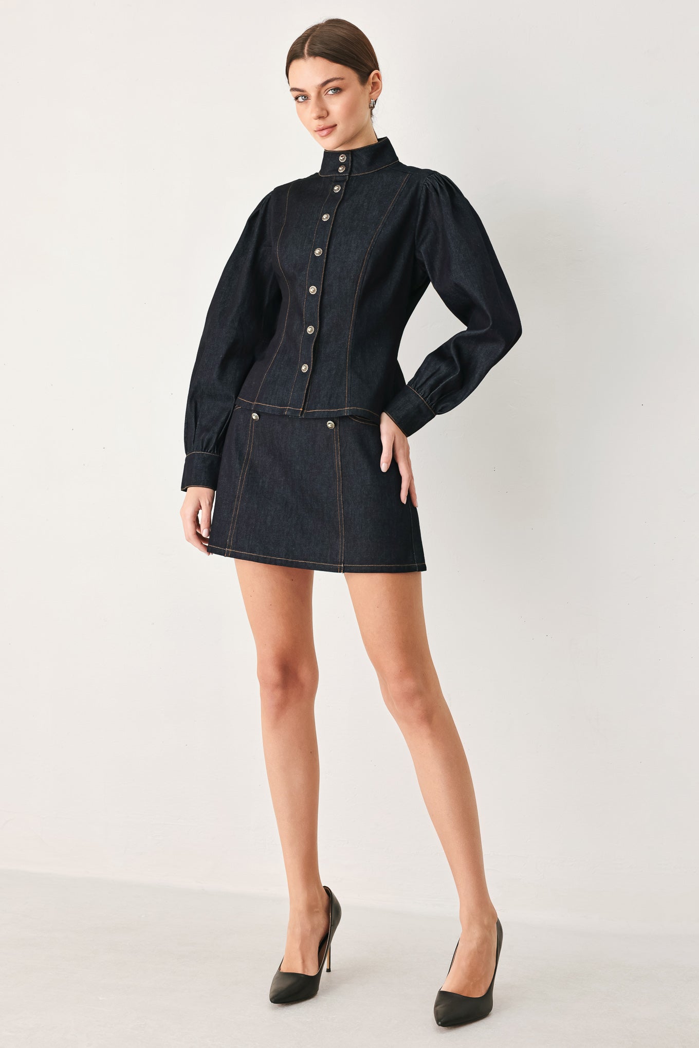 Woman wearing a dark lightweight denim skort with front button detail, pockets and back zipper closure | FREEMARKET