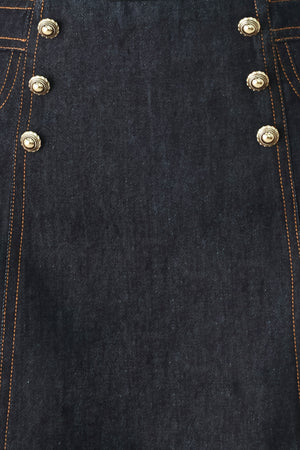 Woman wearing a dark lightweight denim skort with front button detail, pockets and back zipper closure | FREEMARKET