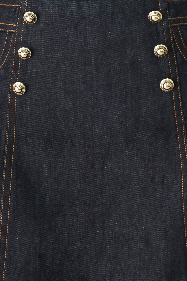 Woman wearing a dark lightweight denim skort with front button detail, pockets and back zipper closure | FREEMARKET