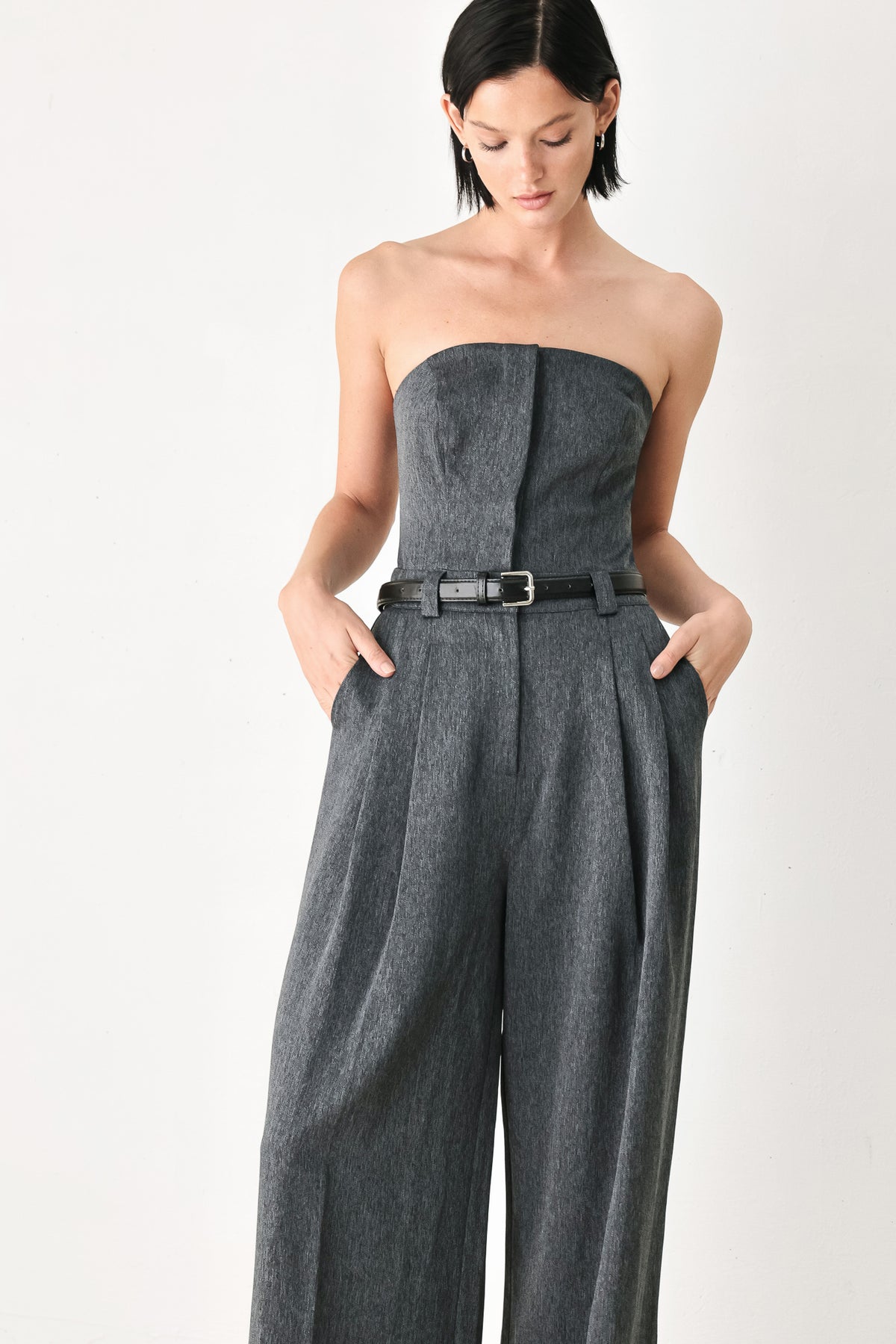 A model wearing a dark gray strapless wide-leg jumpsuit with a matching belt | FREEMARKET