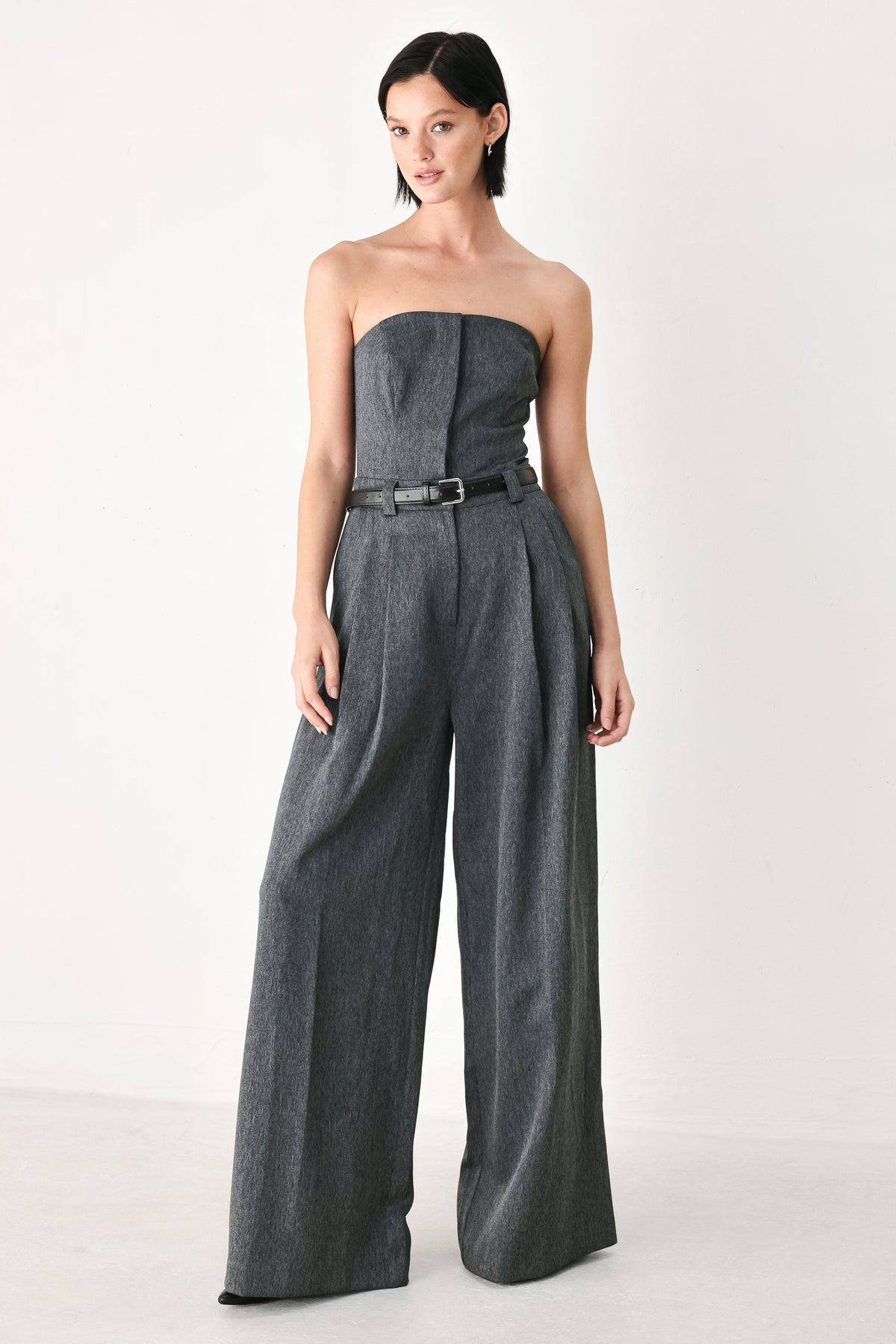 A model wearing a dark gray strapless wide-leg jumpsuit with a matching belt | FREEMARKET