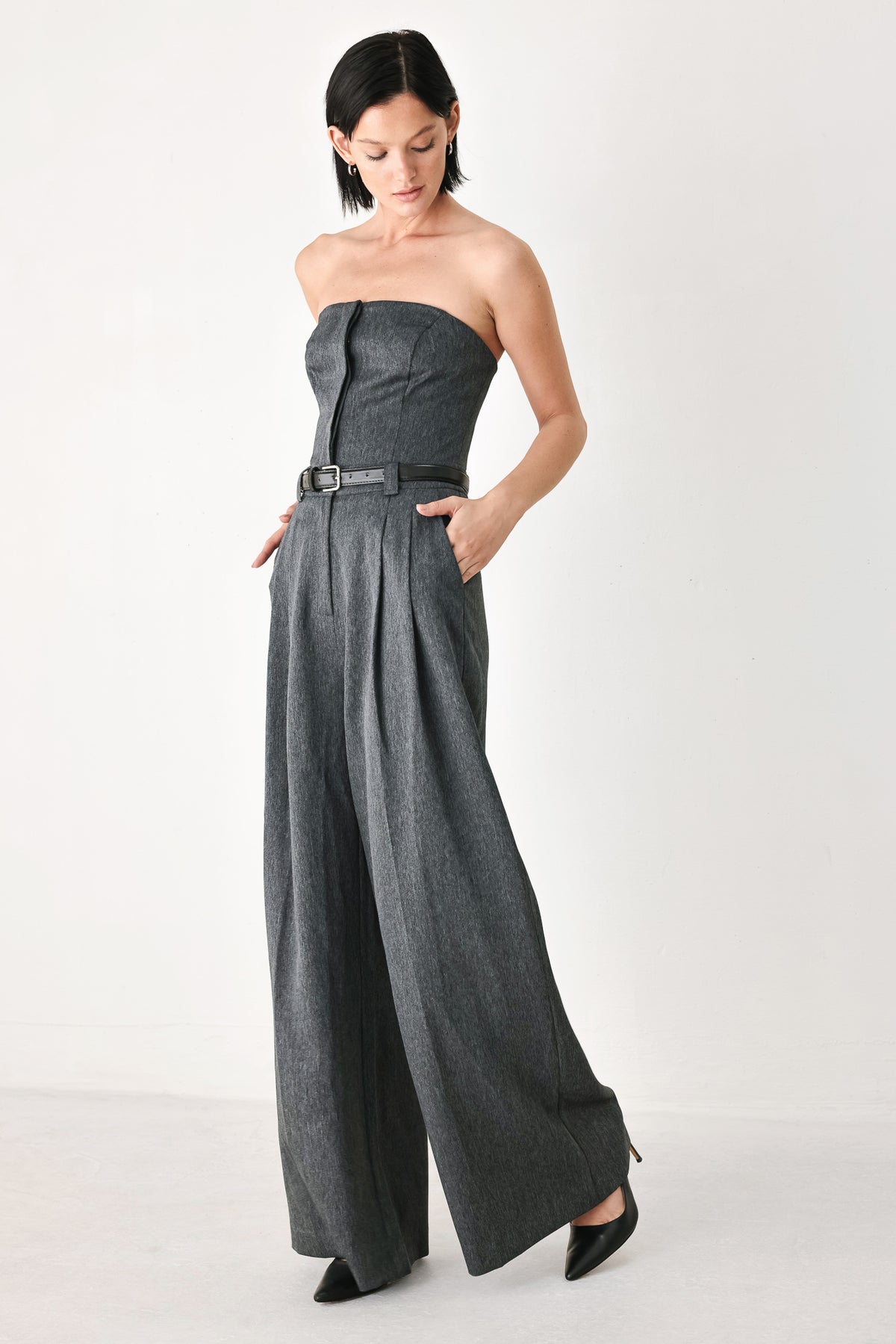 A model wearing a dark gray strapless wide-leg jumpsuit with a matching belt | FREEMARKET