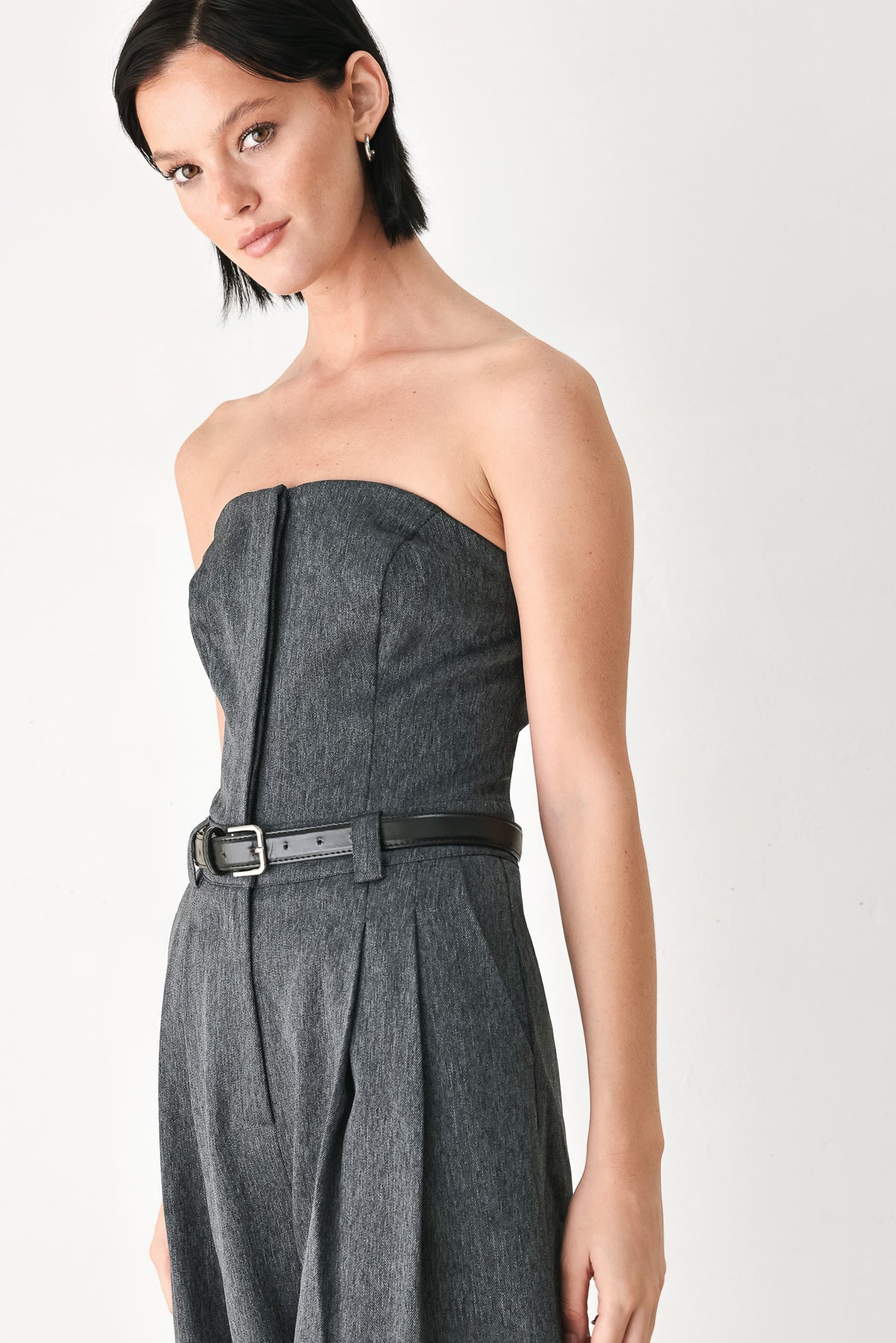 A model wearing a dark gray strapless wide-leg jumpsuit with a matching belt | FREEMARKET