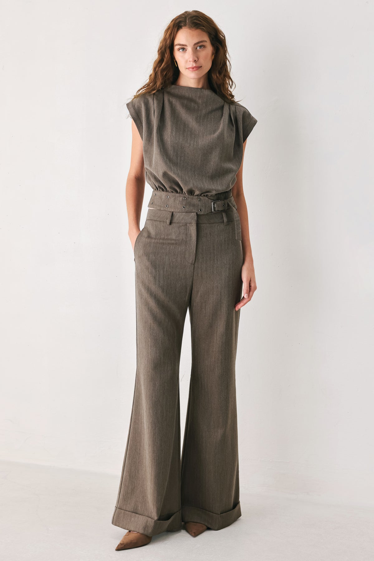 Woman wearing brown tailored flared pants with a big cuff at the bottom | FREEMARKET