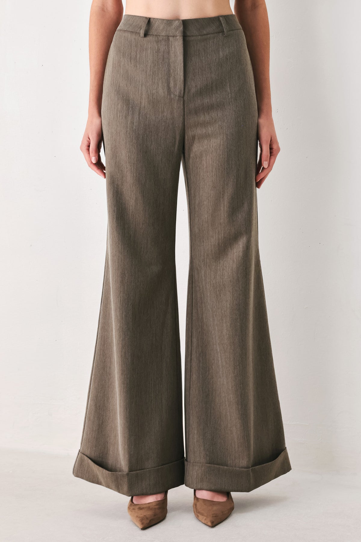 Woman wearing brown tailored flared pants with a big cuff at the bottom | FREEMARKET