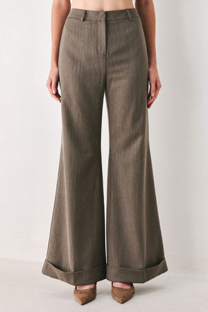 Woman wearing brown tailored flared pants with a big cuff at the bottom | FREEMARKET