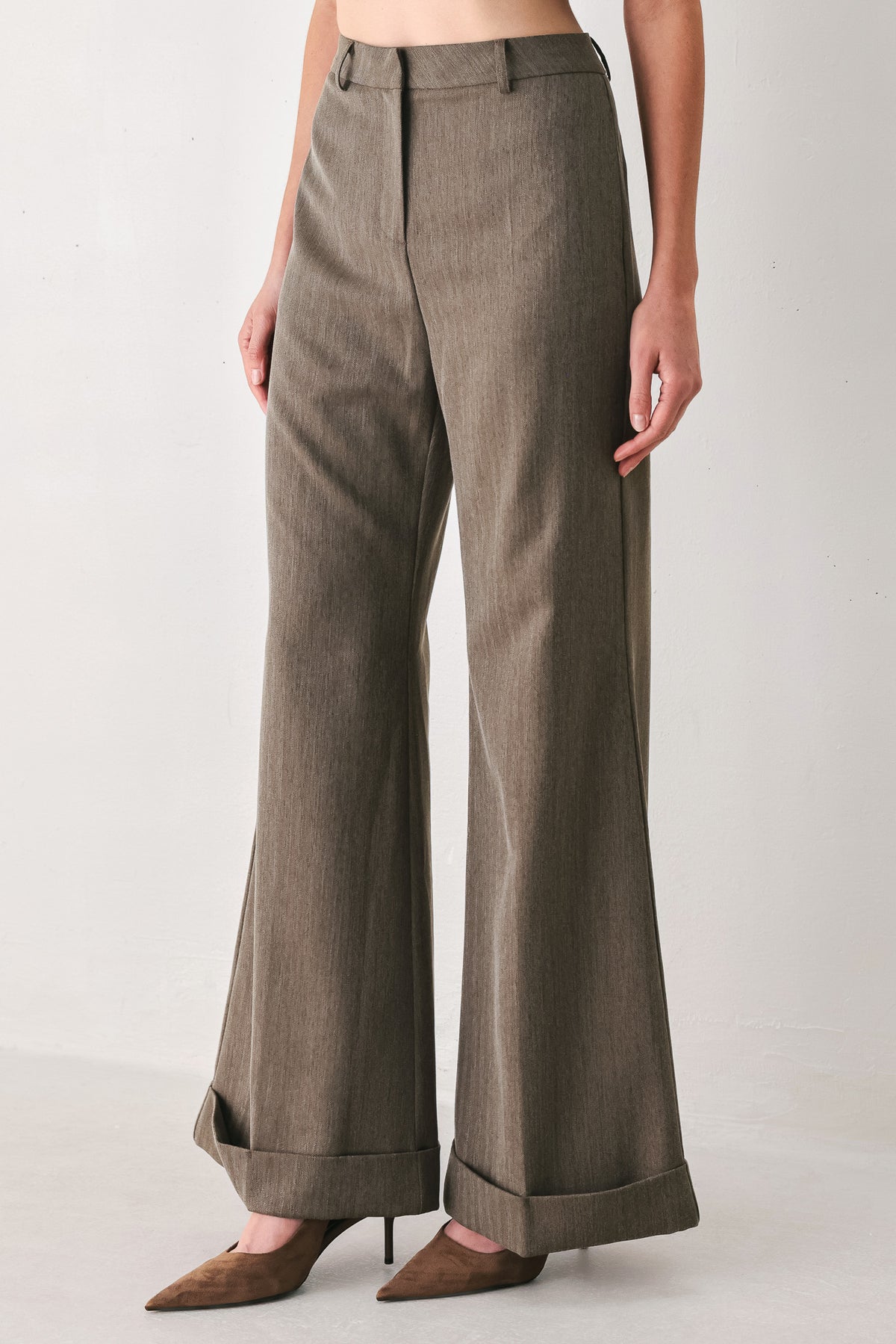 Woman wearing brown tailored flared pants with a big cuff at the bottom | FREEMARKET