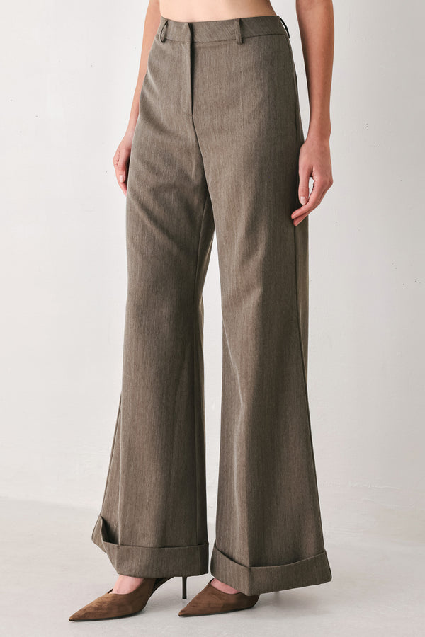 Woman wearing brown tailored flared pants with a big cuff at the bottom | FREEMARKET