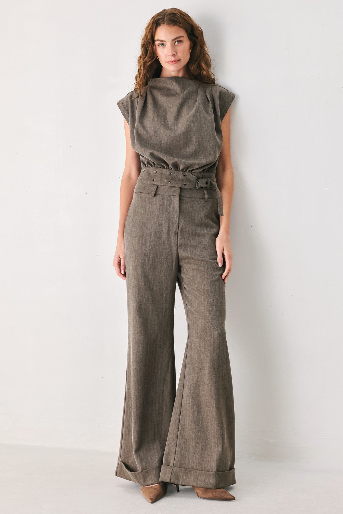 Woman wearing brown tailored flared pants with a big cuff at the bottom | FREEMARKET