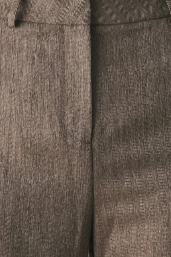Woman wearing brown tailored flared pants with a big cuff at the bottom | FREEMARKET