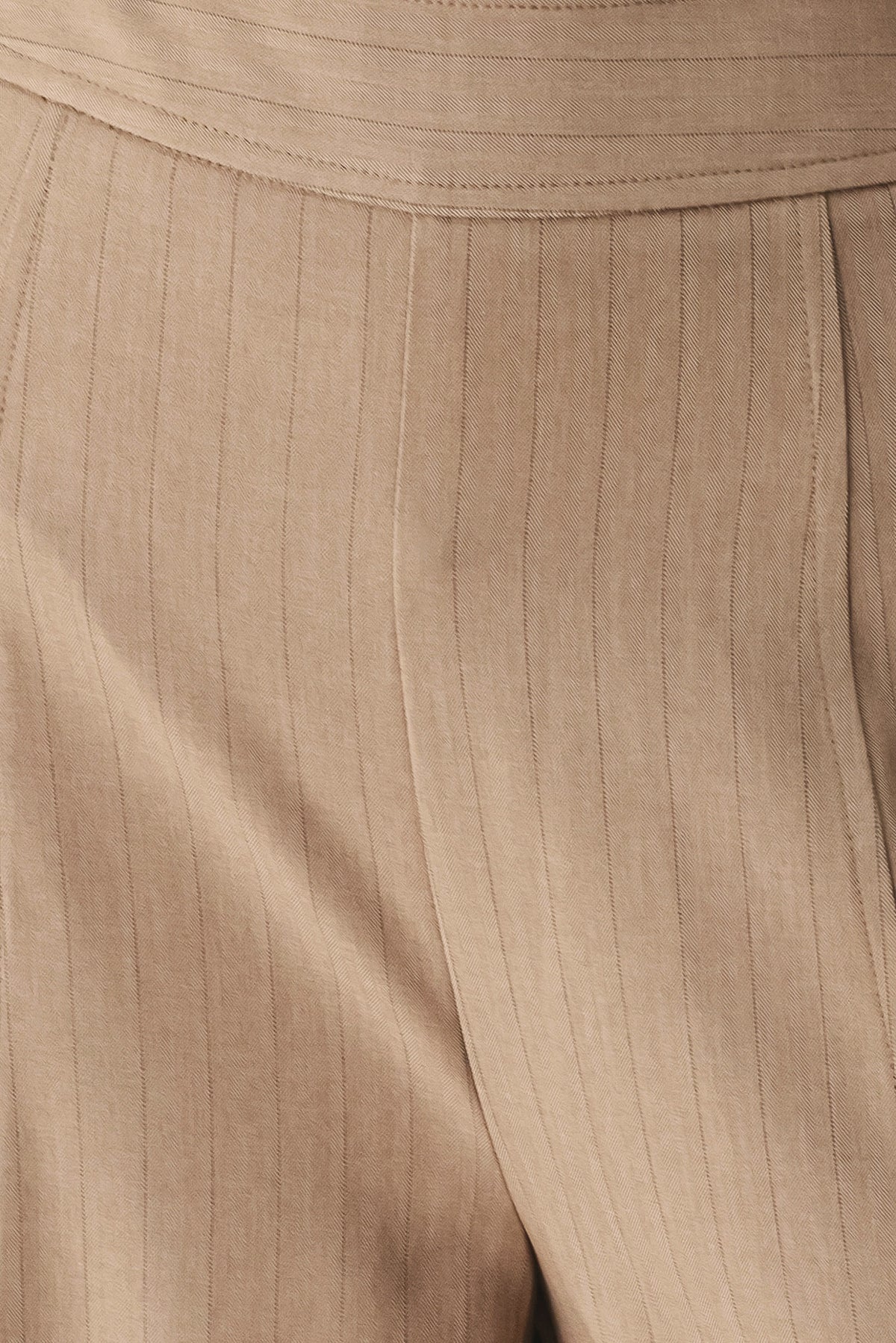 A person wearing high-waisted, wide-leg trousers in a warm taupe-brown color | FREEMARKET